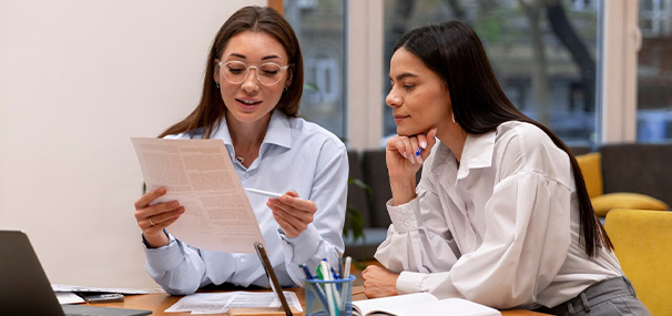 Two females discussing a document at study abroad agencies in kerala